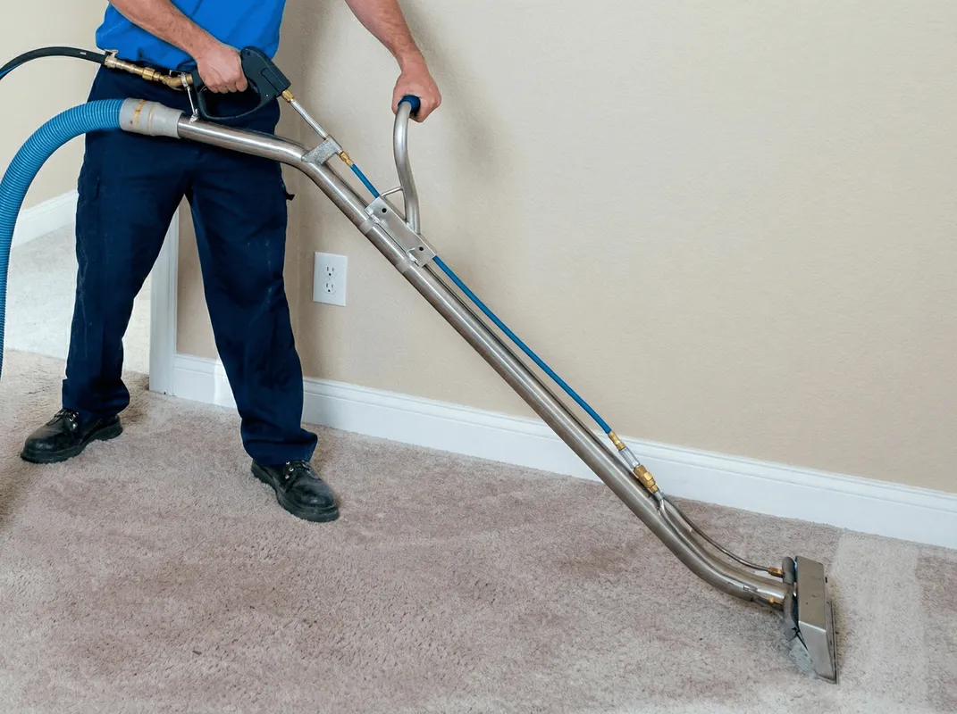 Professional operating a liquid removal machine on a carpeted floor in Raleigh, NC
